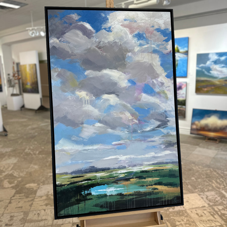 The same landscape painting in a black floating frame, on an easel in Butter Gallery